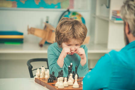 Boy think or plan about chess game, vintage style for education concept. Kid Playing Chess Child and childhood.の写真素材