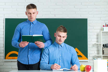 Brother support. Twin boys in uniform on lesson. Brothers in college or university.