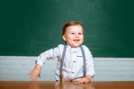 Schoolkid or preschooler learn. Elementary school. Cute preschooler with funny face schooling work. Portrait of preschooler of preschool study indoors.の写真素材