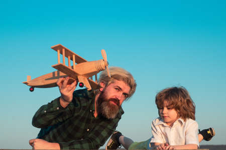 Father and son playing with toy plane outdoor. Family holiday, childhood parenthood. Fathers day.の写真素材