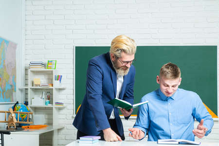 Student and teacher at college. Instructor in training class with students. Portrait of young teacher helping a student during class.の写真素材