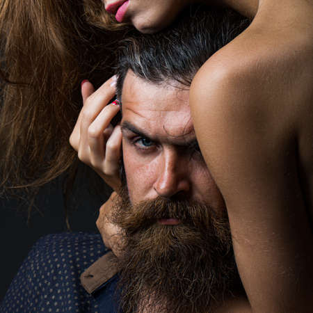 Sexy couple in sensual embrace. Young earded man and girl. Love and feelings, gentle touch and caress.の写真素材
