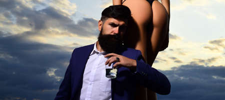 Rich man drink. Bearded businessman in elegant suit with glass of whiskey. Young couple in love...