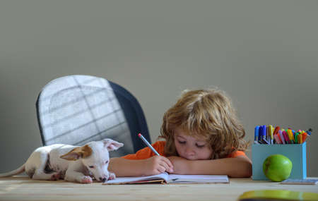 Puppy helping kid child with education learning studying at home.