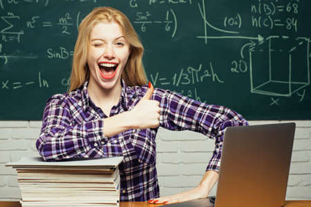 Woman freelancer with good mood using laptop computer. Happy student. Student working on a laptop on...