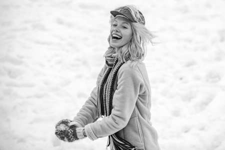 Portrait of a happy woman in the winter. Cheerful girl outdoors. Girl in mittens hold snowball....
