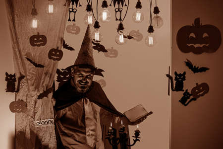 Man pronounces a spell, reads a magic book. Halloween decoration and scary concept. Halloween...