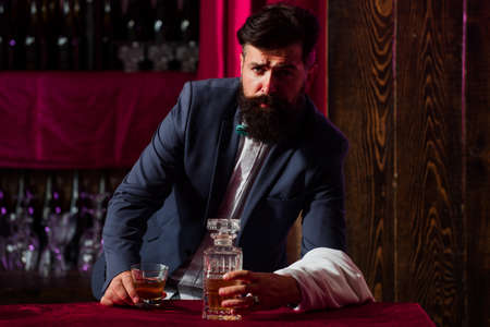 Alcohol concept. Bearded barmen, barkeeper or bartender in bar. Man with beard and mustache, vintage retro design.の写真素材