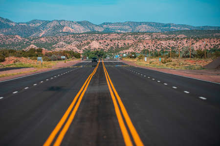 Panorama view of an endless straight road running through the barren scenery of the American Southwest.の写真素材