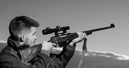 Hunting Gear - Hunting Supplies and Equipment. Hunter with shotgun gun on hunt. Hunter with Powerful Rifle with Scope Spotting Animals.の写真素材