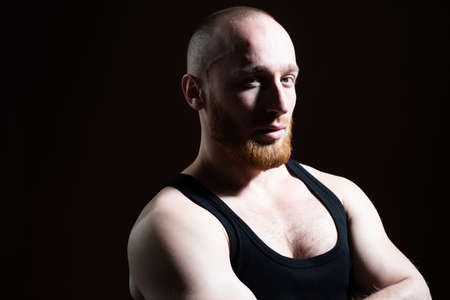 Man close up portrait, with llong shadow on black background low key.の写真素材