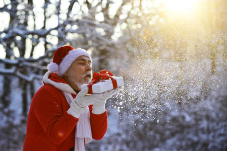 Funny Santa with Gift on Christmas Eve outside.の写真素材