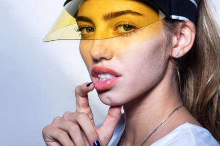 Girl face with sun visor. Hot summer. Fashion portrait of sexy woman close up.