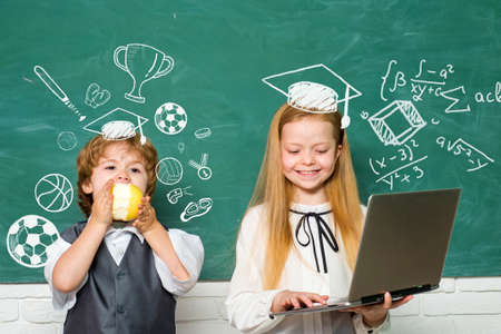 Happy mood smiling broadly in school. Cute little preschool kid boy with Little child girl in a classroom. First grade.の写真素材