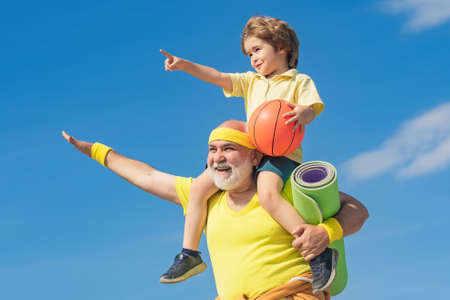 Senior man and child in family health club. Doing sports is free. Grandpa and grandson spotting....