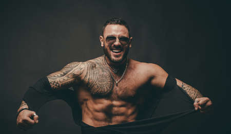 Angry guy. Mans power. Strong man ripped shirt and showing his perfect naked body. Bare torso. Fashion brutal boy.の写真素材