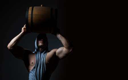 Strong man holds barrel at brewery factory.の写真素材