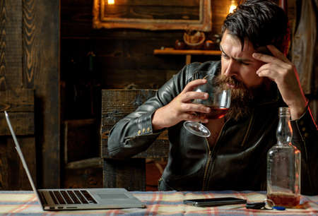 Barbershop, shaving. Macho is drinking by his laptop. Thinking. Considering new ideas.の写真素材