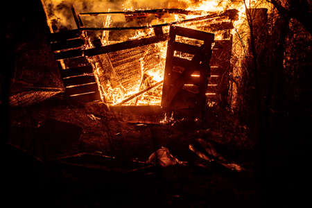 Fire-fighters and a burning house. Burn with flames.の写真素材