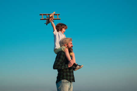 Sweet childhood. Two generations of men father and son have fun and playing with toy airplane....