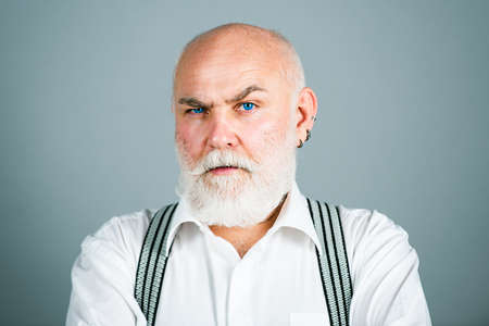 Portrait of elderly caucasian senior old man grandfather on gray. Retirement and pension concept.の写真素材