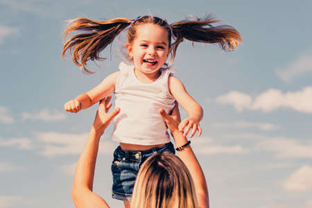 Mothers day. Excited girl. Happy mother and daughter over blue sky background. Mother and daughter...