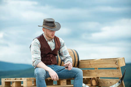 Fashion young cowboy man. Handsome guy with confident face, countryside.の写真素材