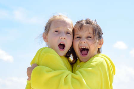 Funny kids face of two cute little children embrace. Funny lovely kids hug. Girlish leisure.