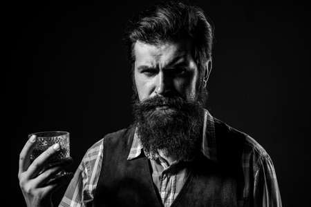 Sommelier tastes expensive alcohol drink. Confident well-dressed man with glass of whisky.