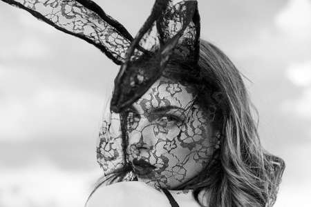 Beautiful sexy young woman wearing a black mask Easter bunny and looks very sensually. Expression face. Nude girl with perfect body are getting ready for holiday. Cute bunny.の写真素材