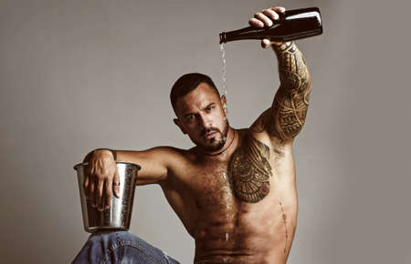 Champagne or wine celebration. Wine festival concept. Handsome man with tattooed body. Handsome...