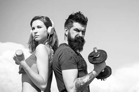 Young strong sporty couple working outside with sports equipment at beautiful blue summer sky background. Active lifestyle and sport activities concept.の写真素材