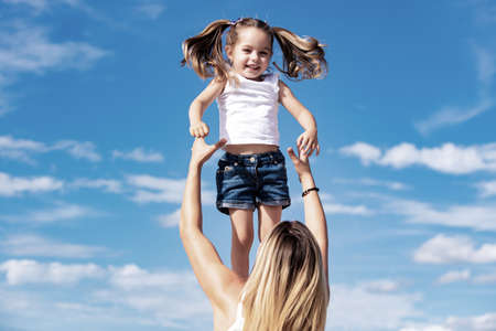 Excited girl. Happy loving family - mother and daughter. Mother and daughter on blue sky background. Happy mothers day.の写真素材
