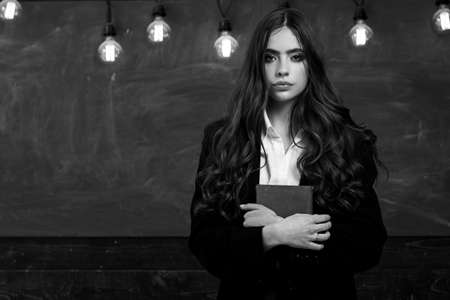 Your text on Blackboard. Ready for school. Young cute teenage girl in classroom at blackboard.の写真素材