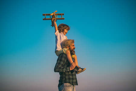 Sweet childhood. Father and son playing with toy plane outdoor. Family holiday, parenthood. Fathers day.の写真素材