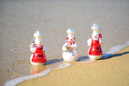 Happy New Year and Christmas. Snow man on sea beach. Xmas travel vacation in hot countries concept.の写真素材