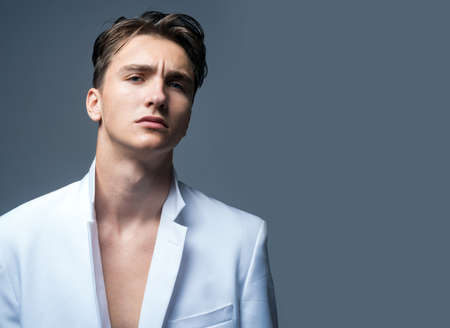 Fashion male model. Sexy man isolated on grey background isolated.