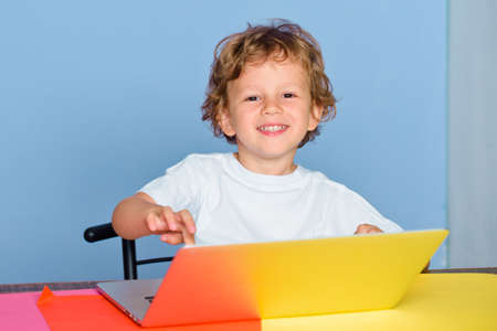 Kid at school with notebook. Child is ready to answer with a blackboard on a background. Funny...