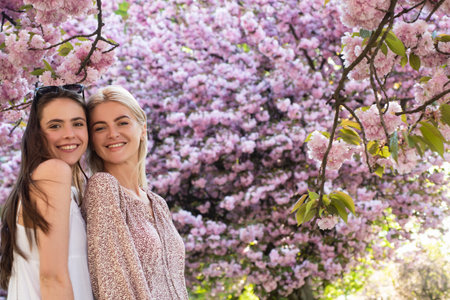 Smiling face of spring girls. Young woman in cherry blossom.の写真素材