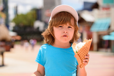 Child eating ice cream. Beautiful little boy eats ice-cream in the summer.の写真素材