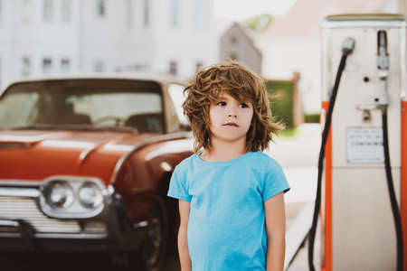 Kid at the gas station. Retro automobile.