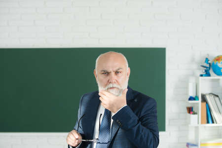 Old male teacher. Senior professor with gray hair in college. Think.の写真素材