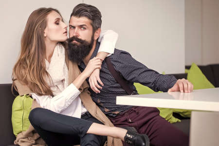 Young couple in cafe. Beautiful stylish emotional lovers embracing sitting close to each other.の写真素材