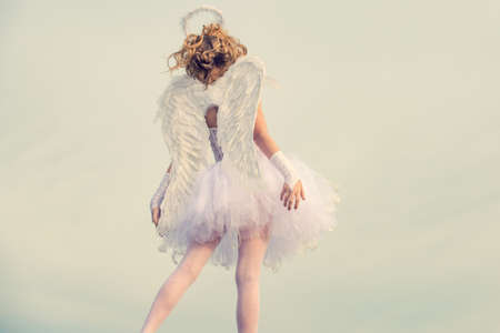 Angel children girl with white wings pray. The God of Love. Valentines day card. A beautiful teen with blonde curly hair as cupid - Valentines Day. Sweet angel girl. Love card.の写真素材