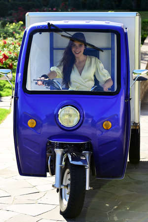 Electric cars. Saving ecology. Smiling woman in funny car.の写真素材