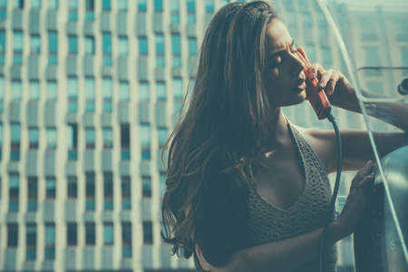 Old fashion town. Vintage concept. Oldstyled city. Woman with payphone. Communication.