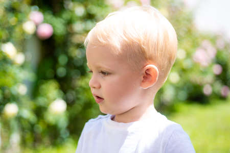 Cute boy face. Closeup portrait of smiling child on outdoor background. Kid smile. Emotion concept.の写真素材