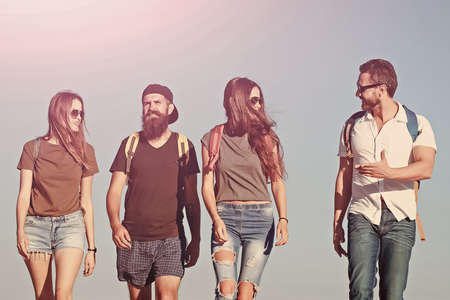 Travel friends on blue sky, travelling. Yong group of people hiking.
