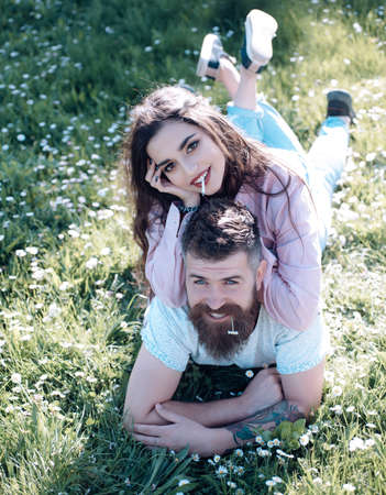 Couple on nature background. Man and woman laying on grass spring day. Couple in love spend time outdoors.の写真素材