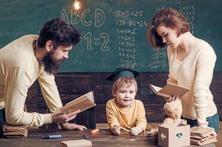 Family cares about education of their son. Father and mother reading books, teaching their son,...